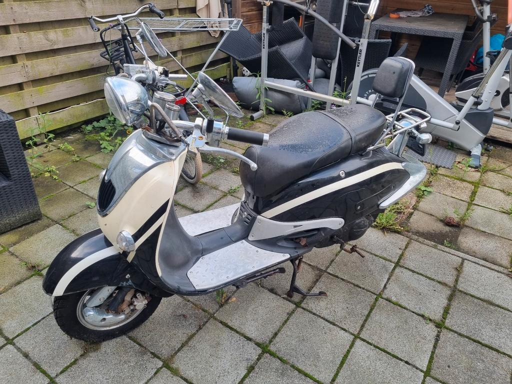 Retro scooter opknapper voor een kratje bier