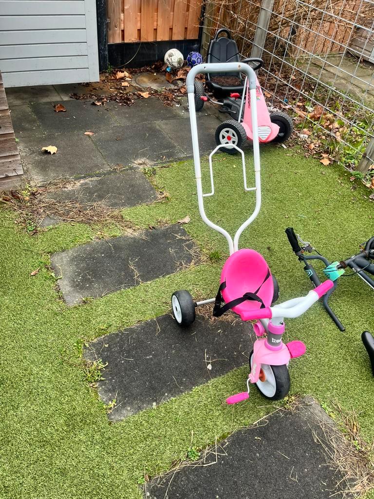Roze driewieler met duwstang gratis