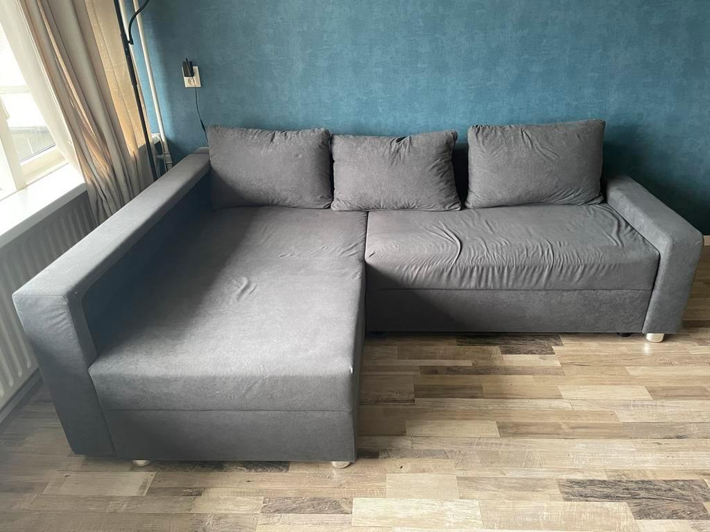 Grijze hoekbank met slaapfunctie en opbergruimte