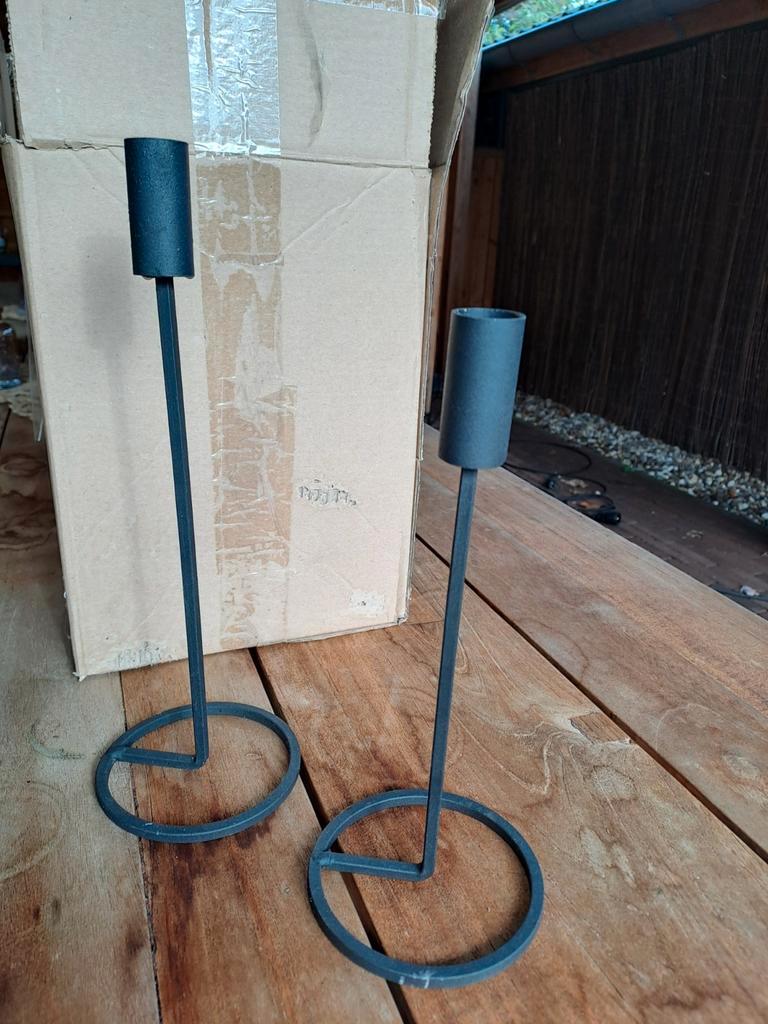 Twee zwarte kaarshouders.